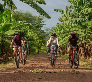 People riding bikes in a farm near Lake Manyara Serena Lodge